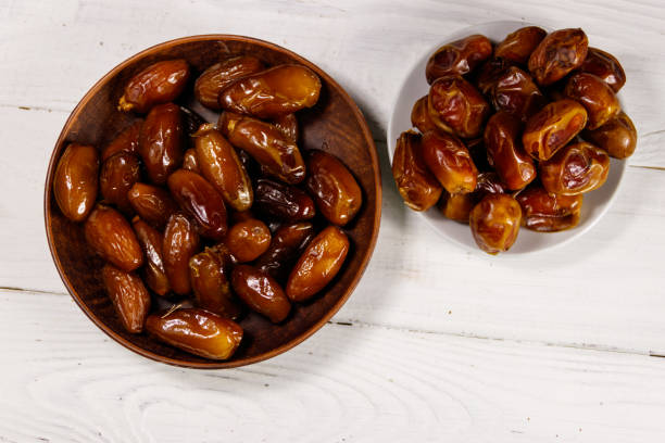 istock Dried dates fruit on white wooden table. Top view 939300154