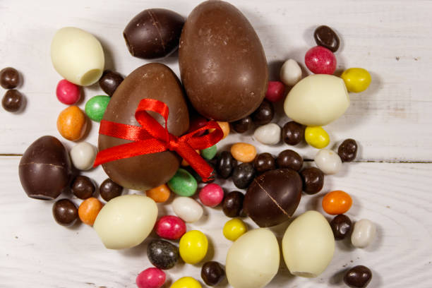 istock Easter composition with chocolate eggs on white wooden background 939300490