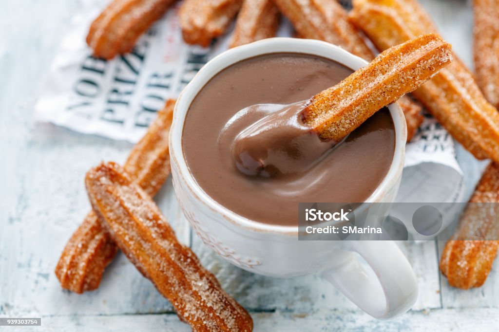 Traditional Spanish dessert churros. Churros with a cup of hot chocolate closeup, selective focus. Churro Stock Photo