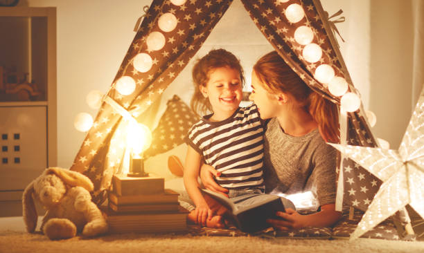 istock r and child daughter with a book and a flashlight before going to bed 939308674