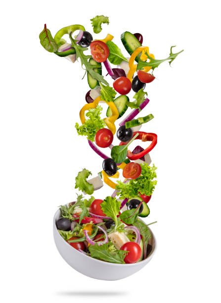 flying vegetable greek salad isolated on white background - vertical drop imagens e fotografias de stock