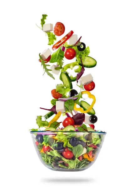 Photo of Flying vegetable greek salad isolated on white background