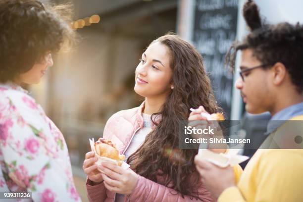 Street Food Friends Eating Burger In Front Of Food Truck Stock Photo - Download Image Now