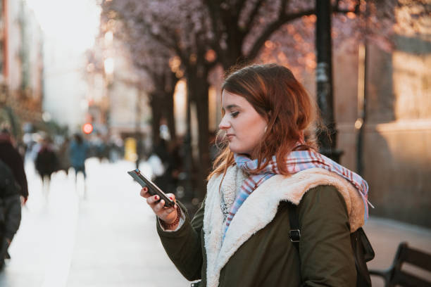 istock Young woman looking at mobile phone screen 939317702