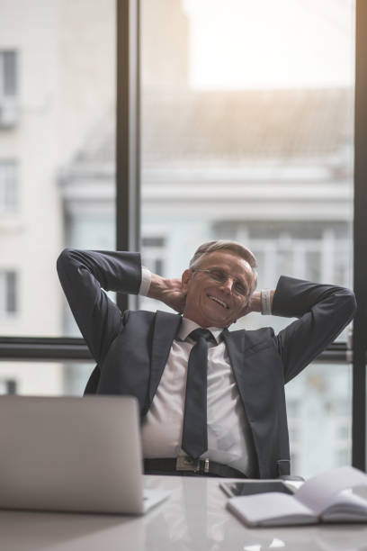 istock Happy old businessman working with laptop 939325608