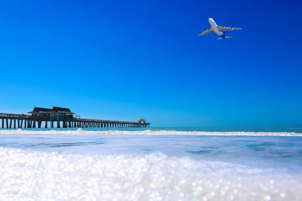 Beach Vacation Destination Naples Florida Naples Florida fishing pier with airplane naples beach stock pictures, royalty-free photos & images