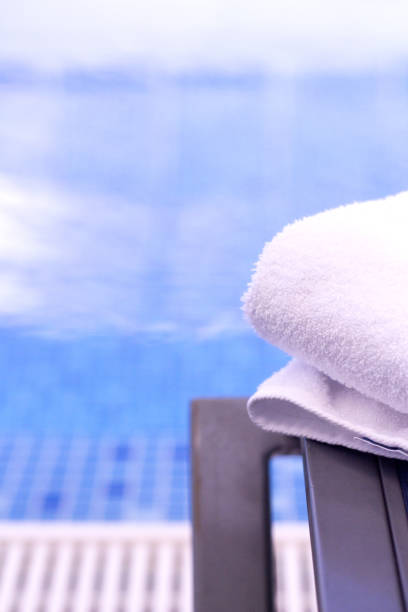 istock Summer pool background with closeup of a white towel 939329664