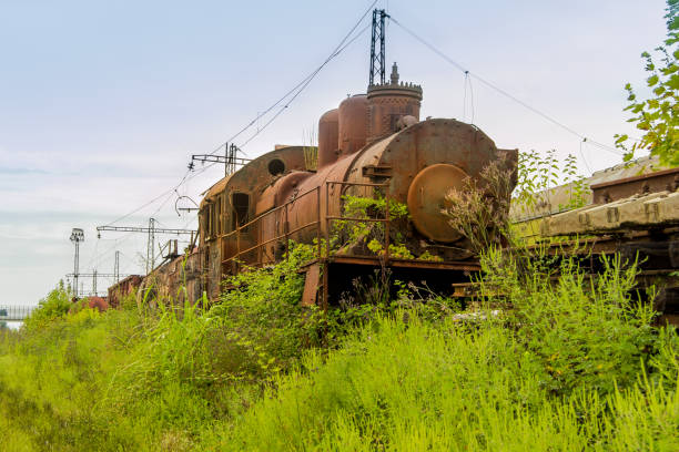 istock Abandoned train. Abandoned railway. Old rusty steam locomotive overgrown by plants 939337974
