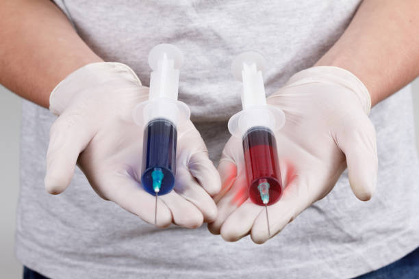istock Doctor hand in white glove hold two syringe with preparation jet from the needle. 939338708