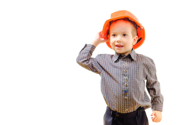 istock Concept, small smiling boy with construction helmet, looks afar isolated on white background with copy space 939341380