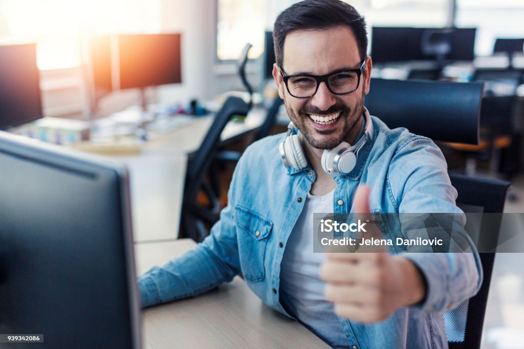 Programmer giving thumb up Young smiling handsome IT expert giving thumb up Thumbs Up Stock Photo