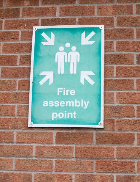 istock green and white fire assembly point sign on brick wall 939342294
