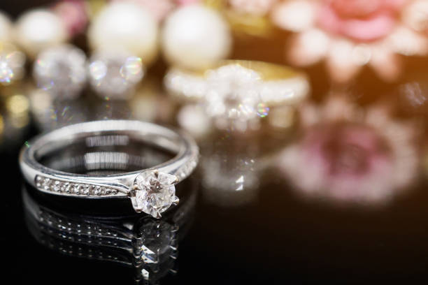 istock Jewelry diamond rings with reflection on black background 939356128