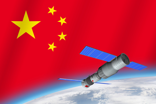3D model of  China's Tiangong-1 space station orbiting the planet Earth with the flag of China in the background. 3D rendering