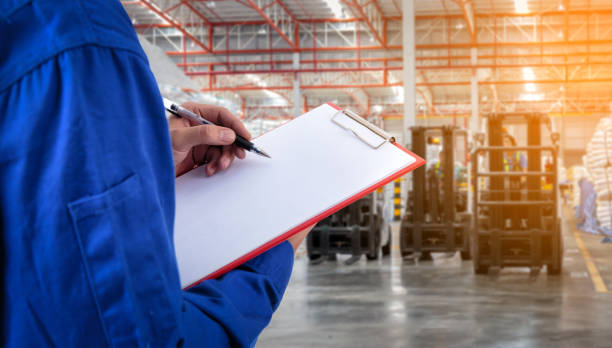 istock Worker checking document in front of the forklift at warehouse import export business. 939369300