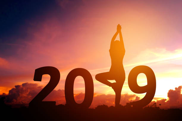 istock Silhouette young woman practicing yoga on 2019 new year 939377064