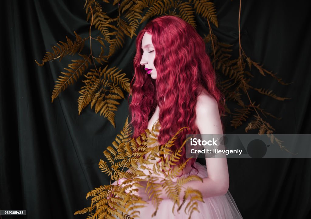 Beautiful pre-raphaelite girl with curly red hair with a flying tulle dress on black background Pre-Raphaelite Stock Photo