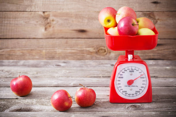 manzanas en escalas rojo - weight scale apple comparison balance fotografías e imágenes de stock