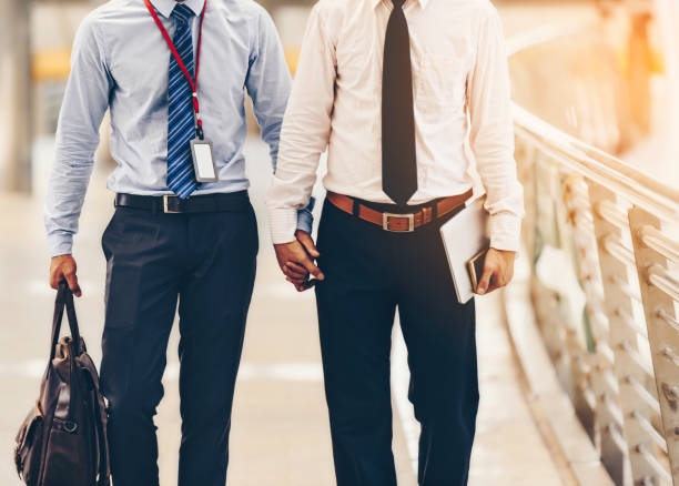 Two Asian business men are walking hand in hand and taking care of each other.The concept of sex couples is correct according to the rights of each person. stock photo