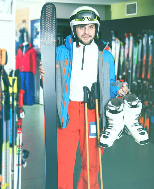 istock Guy in skiing outfit in shop 939399132