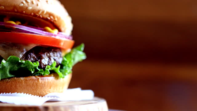 Close-up of burger with copyspace rotating on wooden texture