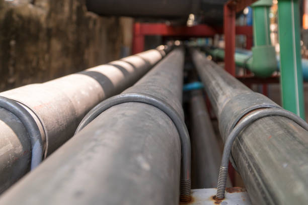 istock Black and black long steel pipe next to the black concrete wall. 939402908