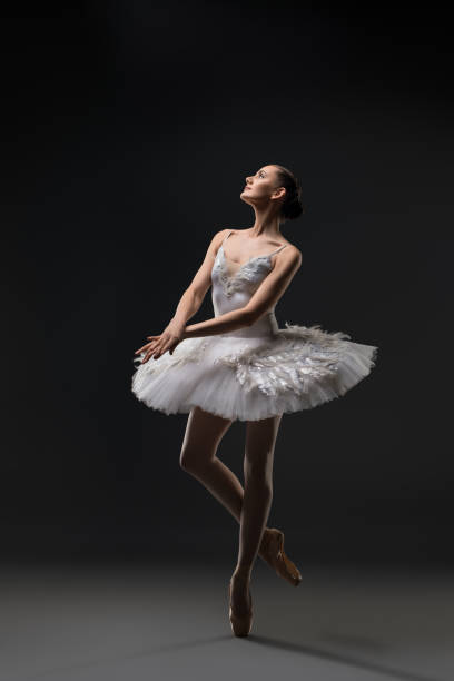 istock Ballerina in white tutu dancing in the dark 939410190