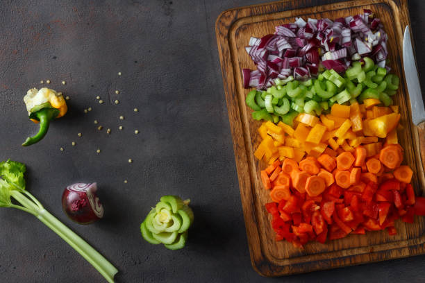 istock Top view sliced fresh vegetables serving on cutting board on dark background with copy space 939423698