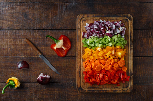 Top view set of sliced fresh vegetables serving on cutting board on wooden table