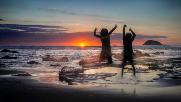 alegria do sol na praia de muriwai - murawai beach - fotografias e filmes do acervo