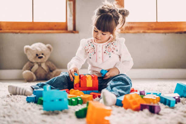 sweet child playing with plastic blocks - brinquedo imagens e fotografias de stock