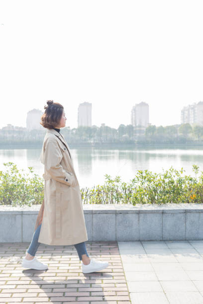 istock young woman walking by lake 939443678