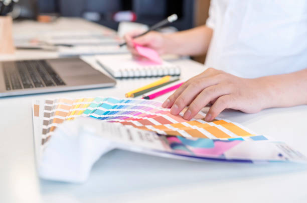 Close up view of male designer pointing on color shade swatch and choosing color for new project Close up view of male designer pointing on color shade swatch and choosing color for new project at his desk in office graphic designer stock pictures, royalty-free photos & images