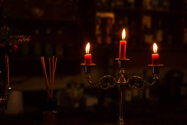 istock Old candlestick holder in front of a dark red background 939454524