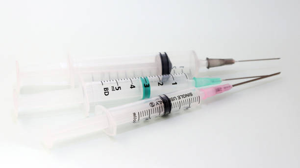 istock Three disposable medical syringes on a white background. 939457356