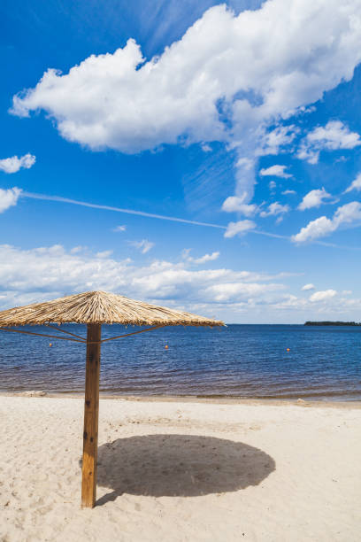Sunshade on sandy beach on summer day Artificial canopy from the sun in the form of a large mushroom stands on a deserted sandy beach by the sea on a hot day civilized stock pictures, royalty-free photos & images
