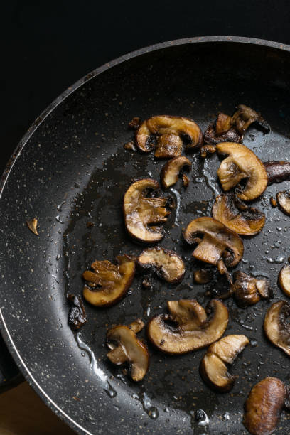 istock Fried mushrooms in frying pan background. Dish for dinner. Close up view 939460606