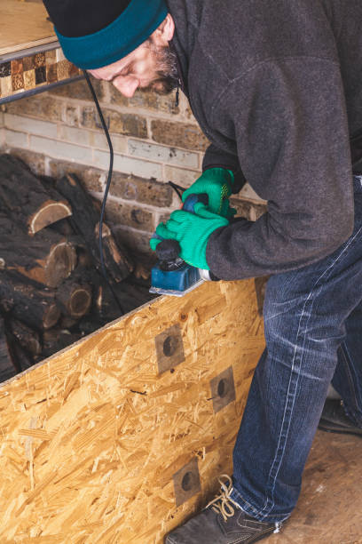 istock man scratches wood plate with electric plane 939460650