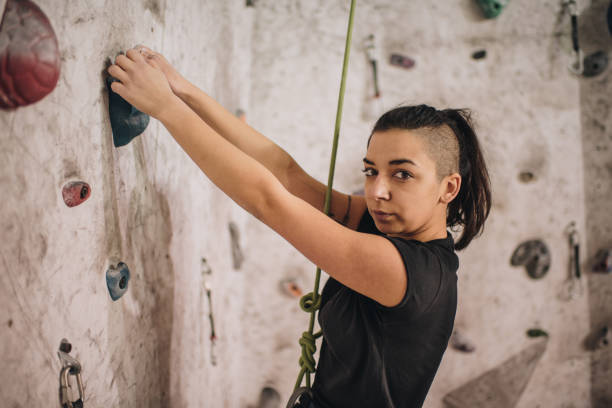 istock Female athlete practicing climbing on a wall in bouldering gym. 939461034