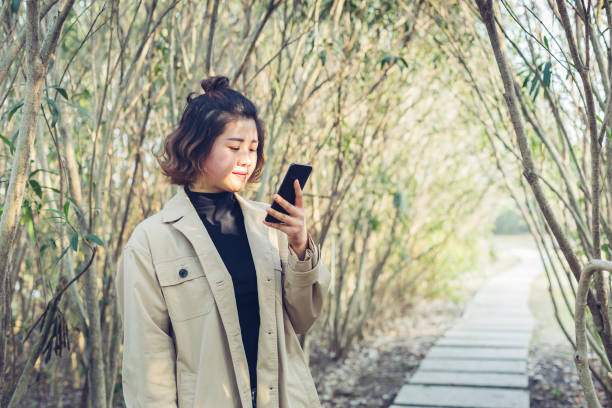 istock woman texting messages in park 939463682