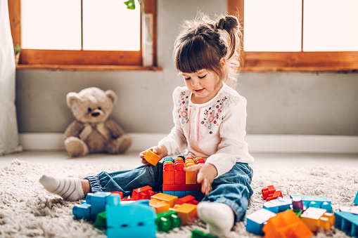 Sweet child playing with plastic blocks