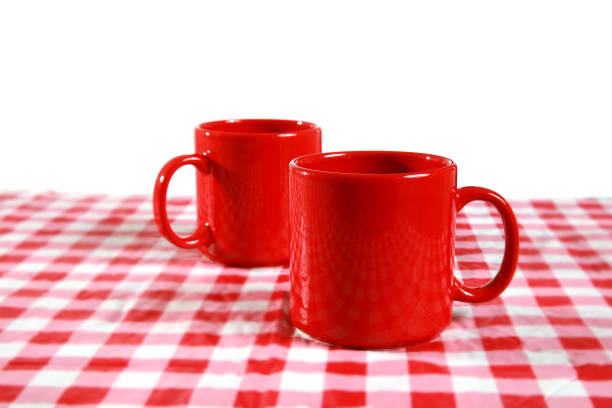 Mugs with a hot drink stand on the table on the background of the window