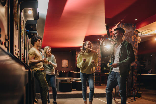 istock Young happy couple having fun with their friends while playing darts in a pub. 939467666