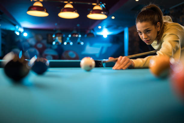 istock Young concentrated woman playing billiard in a pool hall. 939468916