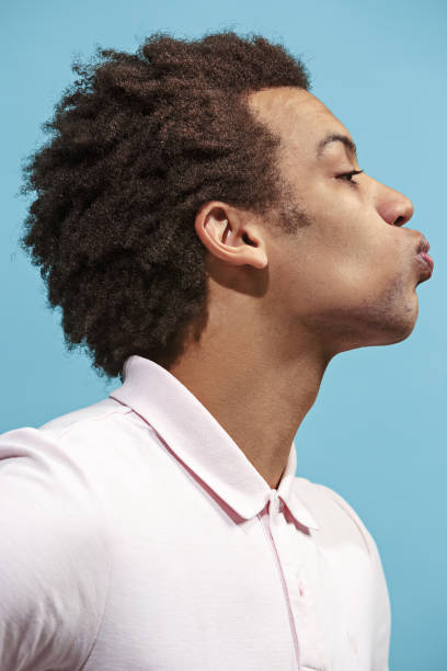 retrato de hombre atractivo afro con beso aislado sobre fondo azul - blowing men kissing blowing a kiss fotografías e imágenes de stock