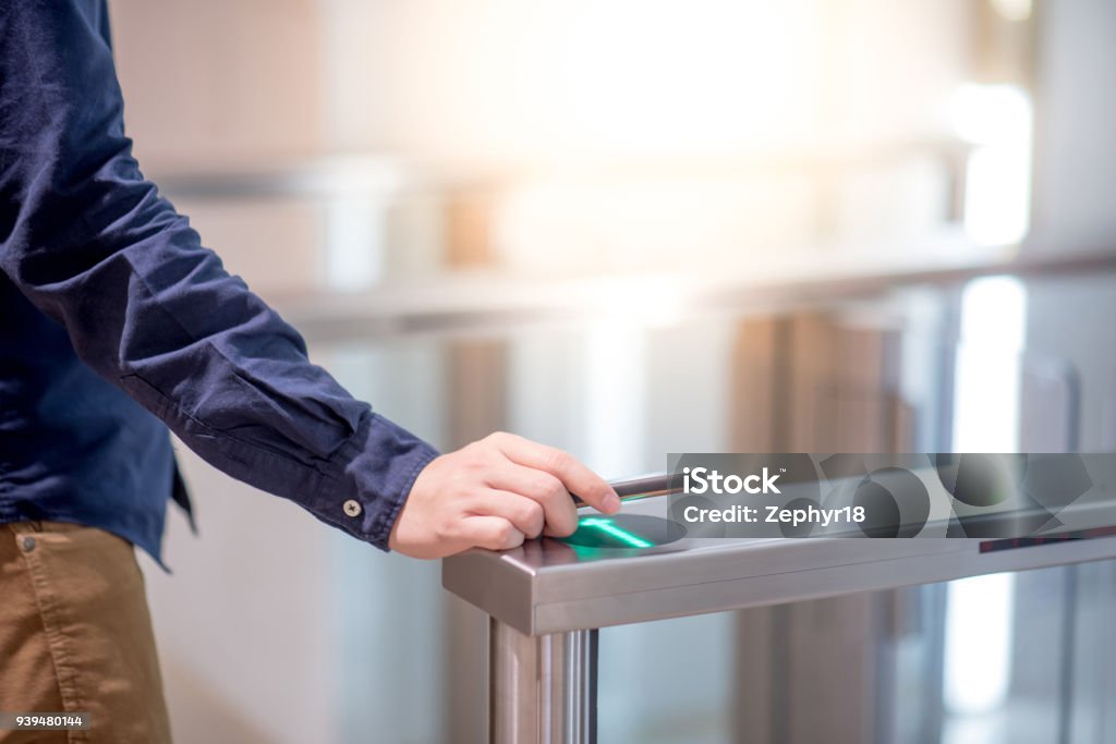 Male hand using smartphone to open automatic gate machine in office building Building Entrance Stock Photo