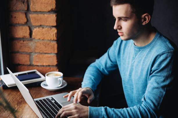 istock Business man with laptop in a cafe Sits opposite the window 939480698