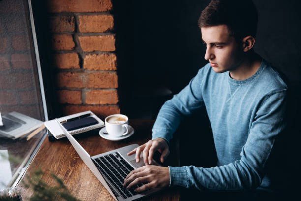 istock Business man with laptop in a cafe Sits opposite the window 939480740