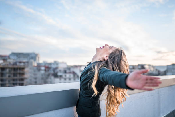 istock Office lady celebrating successful day on the roof 939483808