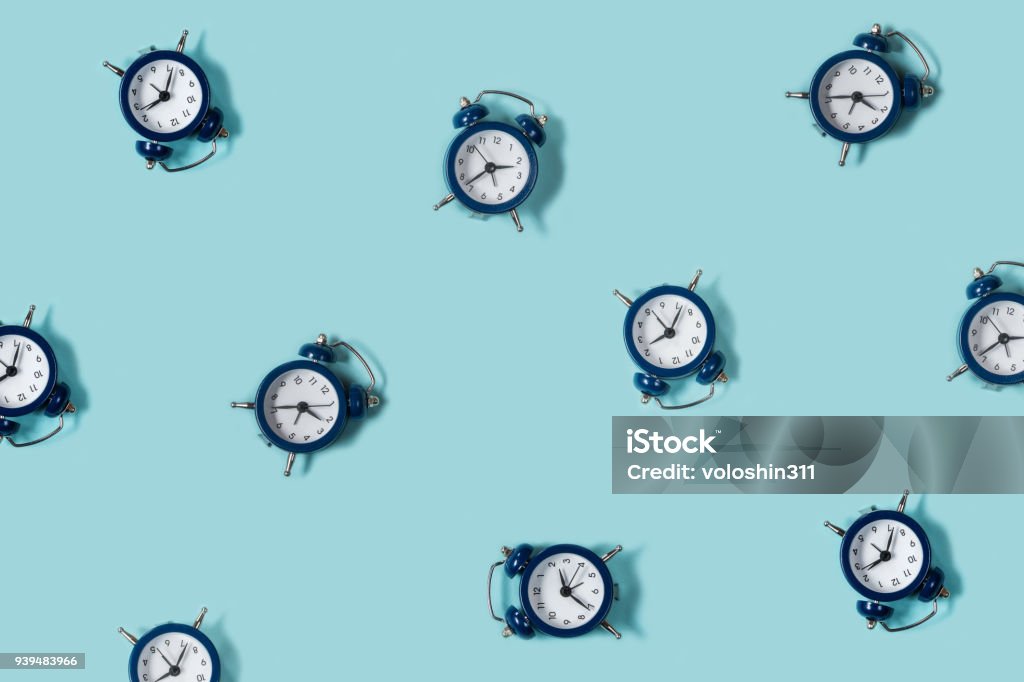 Endecha plana retro hermoso nuevo reloj despertador sobre fondo de color azul. Patrón. Arriba - Foto de stock de Tiempo libre de derechos
